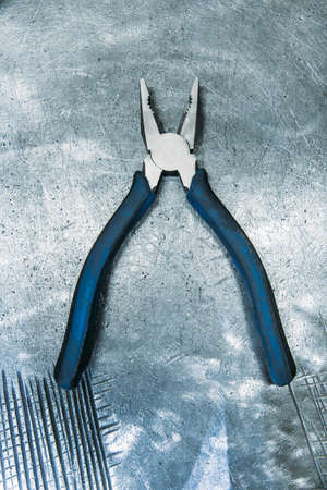 Pliers lying on metal tableの写真素材