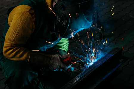 sparks while welder uses torch to welding
