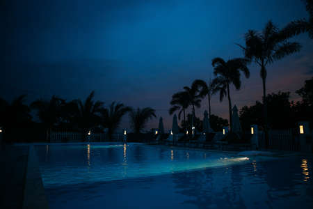 Swimming pool in night illumination tropical islandの写真素材