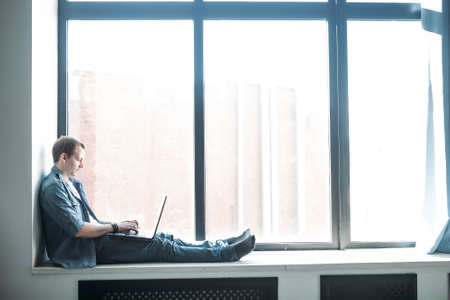 handsome hipster modern man designer working home using laptop at homeの写真素材