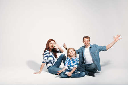 Happy family portrait sitting on white background isolatedの写真素材