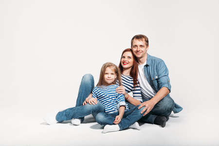 Happy family portrait sitting on white background isolatedの写真素材