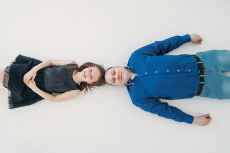 Happy family father daughter portrait lying on white floor room studio blue