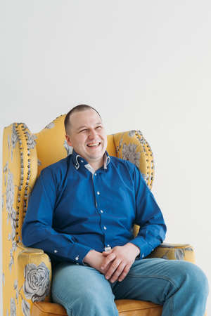 Handsome man smiling in black dress siting on the chairの写真素材