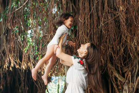 happy mother with little daughter holding in hands and throw up in the air, amazing family moment. mothers dayの写真素材