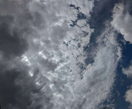 Thunderstorm clouds in the sky. Black-white-gray. A piece of blue sky