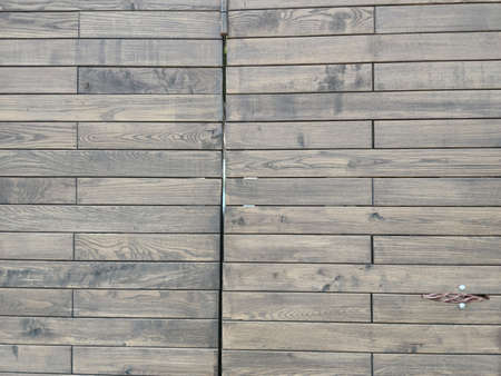 Wooden door with a copper handle. Brown boards. Black nails