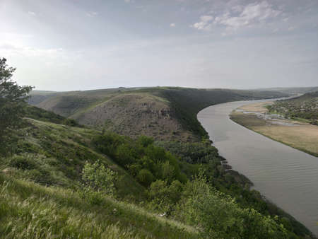 Blue river with yellow reeds. Green mountains. Moldovaの写真素材