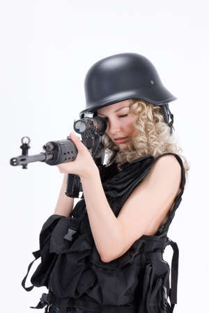 Young blonde woman dressed in military style with weaponの写真素材