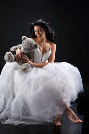 Young beautiful woman in a wedding dress on a studio backgroundの写真素材