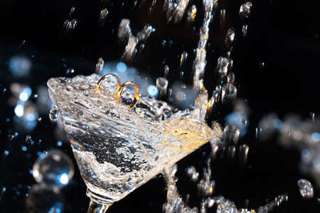 Two engagement rings in the glass on a studio backgroundの写真素材