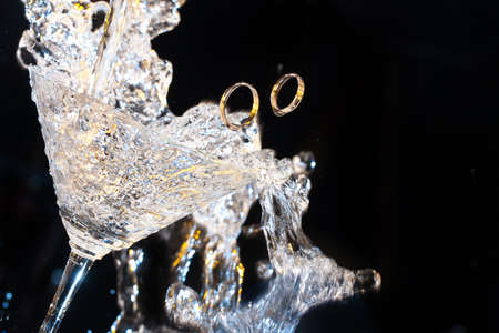 Two engagement rings in the glass on a studio backgroundの写真素材