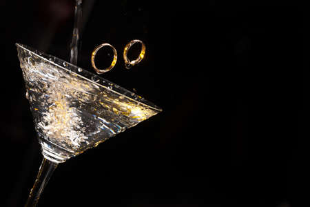 Two engagement rings in the glass on a studio backgroundの写真素材