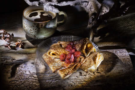 Pancakes and cup of coffee on a wooden deskの写真素材