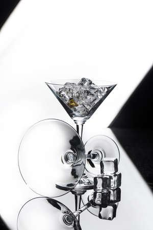 Two glasses and crystals of ice on a glass studio backgroundの写真素材