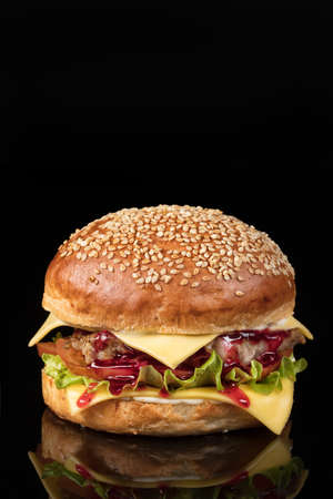 Burger with beef and vegetables on a reflecting glass backgroundの写真素材