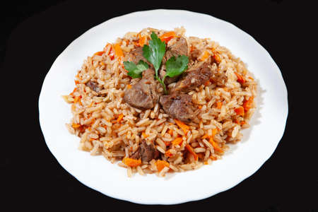 Plate with an asian food pilaw on a black studio backgroundの写真素材