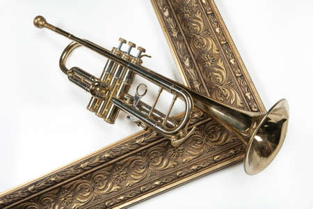 Trumpet and golden frame on an isolated studio background