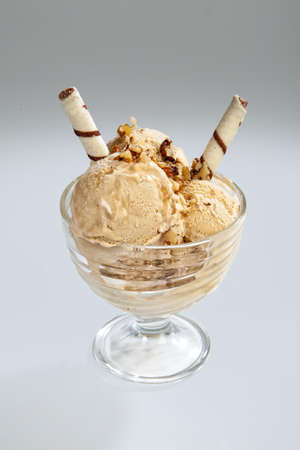 Glass with icecream and cookies on a studio background