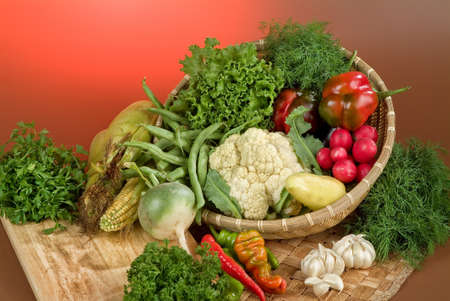 Wicker basket and vegetables on a studio backgroundの写真素材