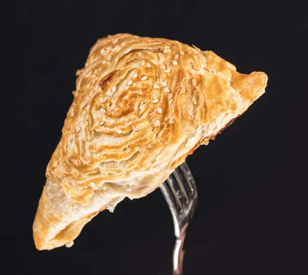 Pie on a fork on a black studio backgroundの写真素材