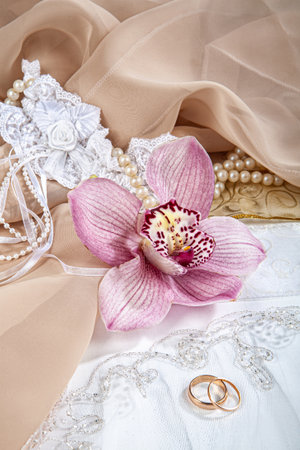 Two wedding rings and flowers on a fabric backgroundの写真素材