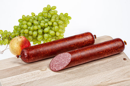 Sausages and fruits on a wooden desk on isolated backgroundの写真素材