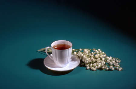 Still life with cup of tea and lily of the valleyの写真素材