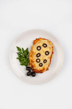 Roasted meat with sauce and olives on a plate studio backgroundの写真素材