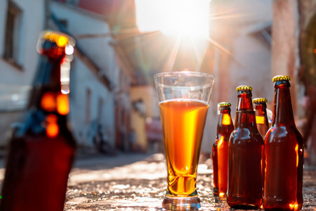 Bottles and glasses of beer in an old small townの素材