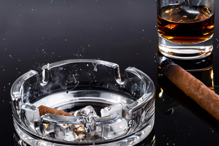 Glass of whiskey with cubes of ice with splashes and reflectionsの素材