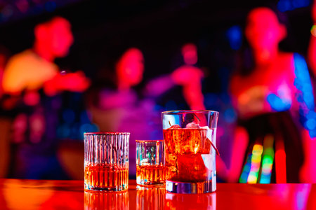 Glasses with coctails and whiskey at the bar in the night clubの素材