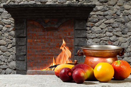 Different fruits and glass of wine on a table near the fireplaceの素材