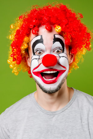 Young positive man in clown make up and wigの素材