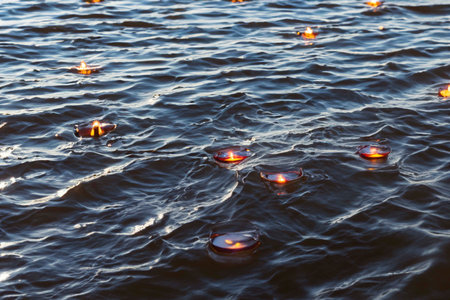 Many candles floating on a river surfaceの素材