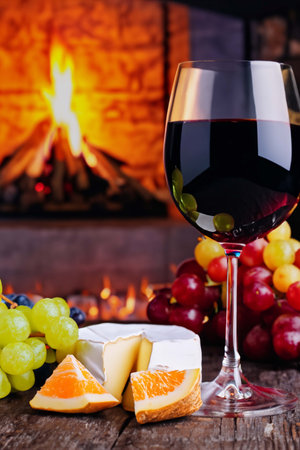 Glass of wine and fruits on an old wooden tableの素材
