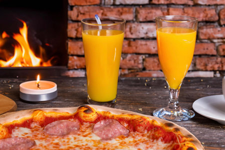 Pizza with ham, cheese and tomatoes and a glass of juiceの素材