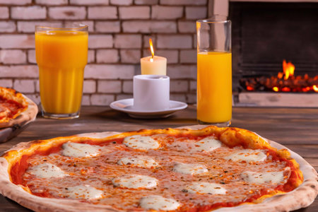 Pizza with ham, cheese and tomatoes and a glass of juiceの素材