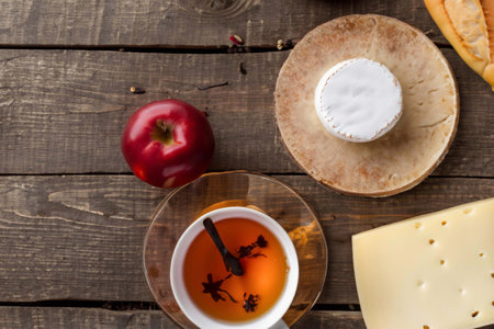 Cup of tea and different food on an old wooden deskの素材
