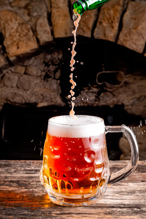 Glass of beer with fireplace at the backgroundの素材