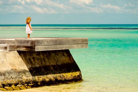 loneliness little girl looking at the exotic oceanの写真素材