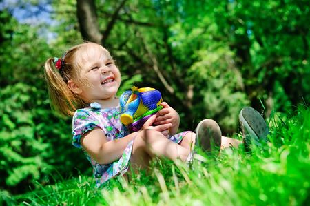 happy girl holding new toys for sandbox in the parkの写真素材