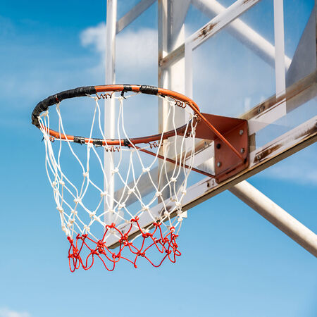 Grunge basketball hoop in court on blue sky background