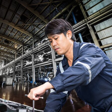 Machinery repairman working in the industrial factoryの写真素材