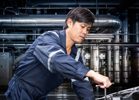 Machinery repairman working in the industrial factory