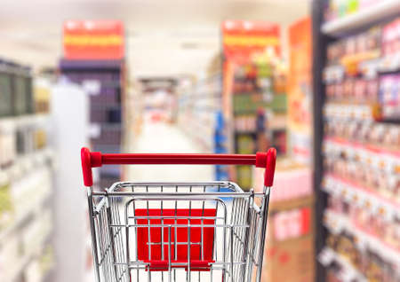 Shipping cart in blurred supermarket interior for business conceptの写真素材