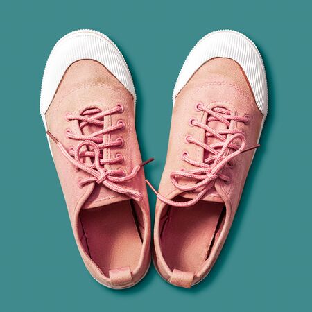 Pink sneaker shoes, top view, for women isolated on green backgroundの写真素材