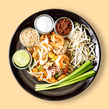 Thai fry noodle with shrimp, Pad Thai is famous street food for Thailand, isolated on cream backgroundの写真素材