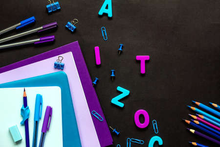 The concept of going back to school. School supplies blue and purple, notebooks, pencils, pens,...