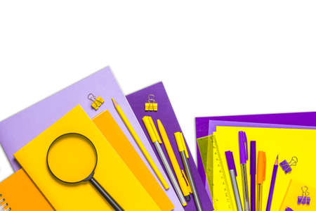 The concept of going back to school. Yellow and purple school supplies, notebooks, pencils, pens, books on a white background. Space for text. The view from the topの写真素材
